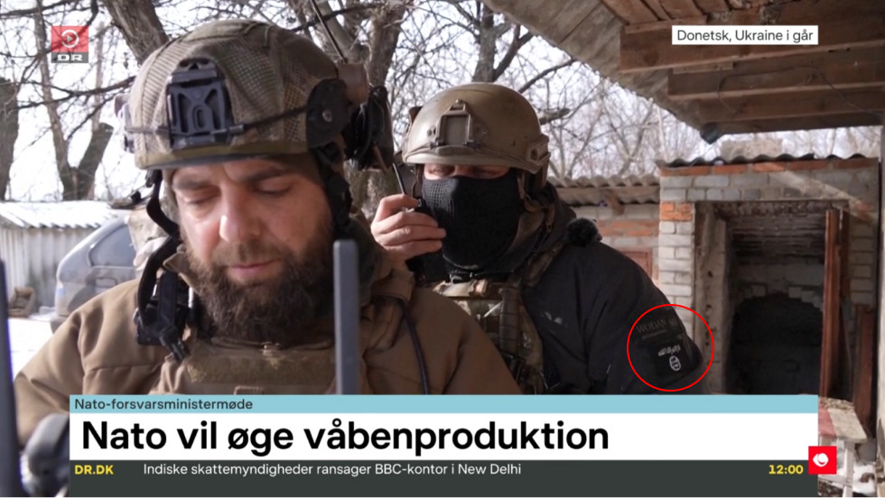 Záběr z dánské TV s ukrajinským vojákem a nášivkou vlajkou teroristické organizace Islámský stát.
